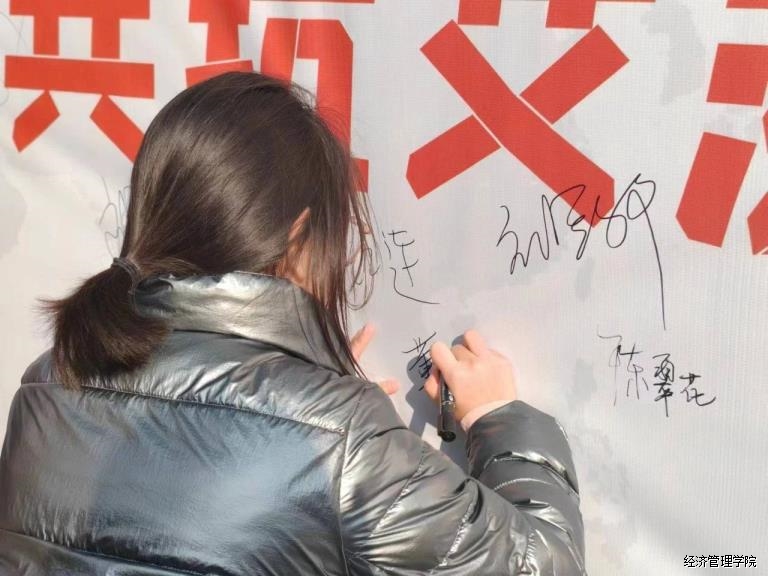 师生在“防艾”宣传板上签名