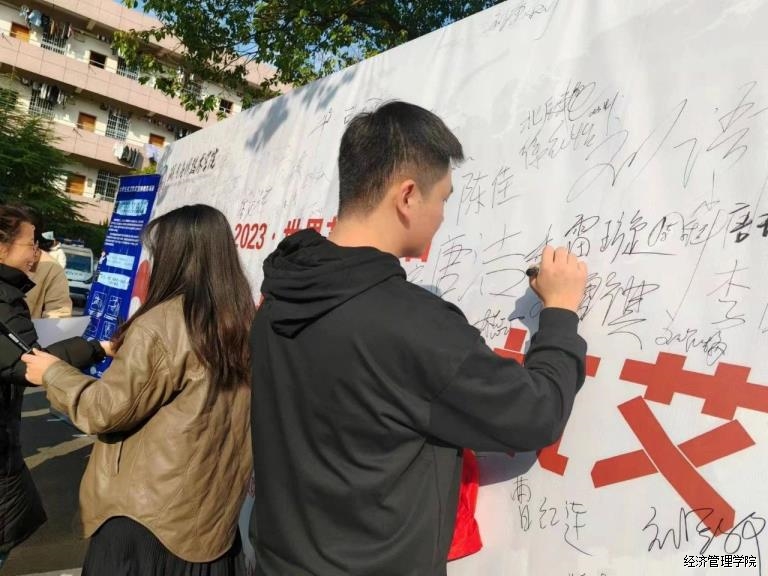 师生在“防艾”宣传板上签名